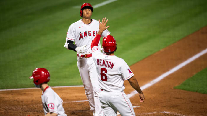 Shohei Ohtani is greeted by Anthony Rendon after scoring a run against the Mariners at Angel Stadium.